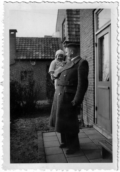 Foto. Johannes Prins (1915-1976) uit Kampen met op de arm zijn oudste dochter, in de achtertuin van Burgemeester Schimmelpennincklaan 
10 in Wijhe. De foto is vermoedelijk gemaakt tussen oktober 1941 en april 1942.
